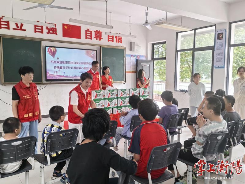 ▲志愿者为孩子们送上中秋慰问品。
